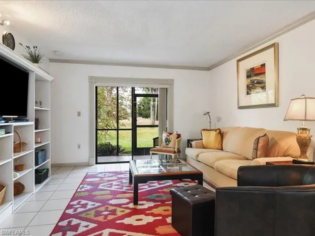 Tiled living room with crown molding and a textured ceiling