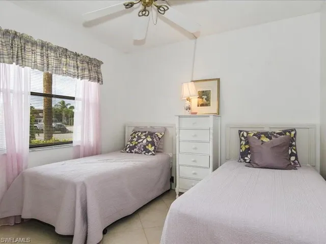 Bedroom with ceiling fan and light tile patterned flooring