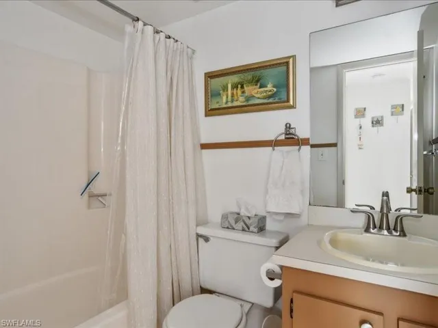 Full bathroom with shower / bath combo, vanity, and toilet