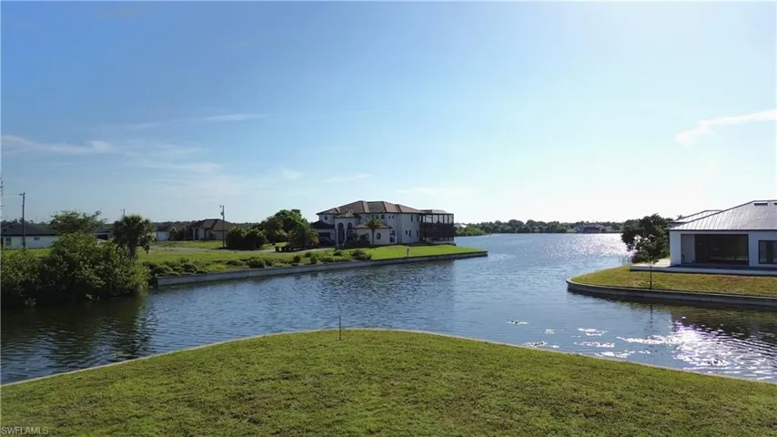 Expansive waterfront setting featuring a grassy bank and direct access to to the Lake