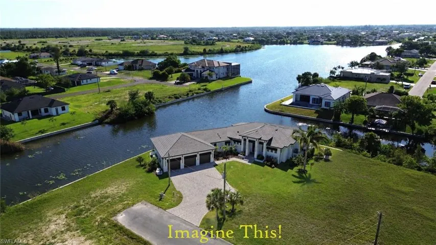 IMAGINE IF THIS WERE YOUR HOME......Contemporary waterfront home featuring a paver driveway, three-car garage, and a lush green lawn with every primary room overlooking the water and pool deck.