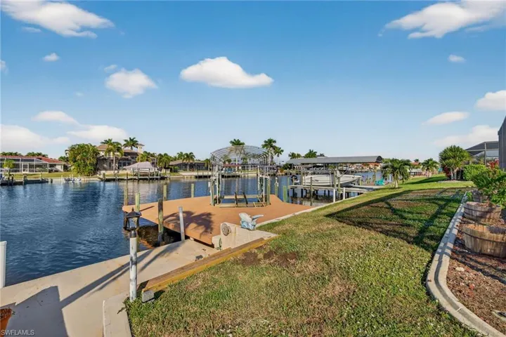 Dock featuring a water view, boat lift, and a lawn.  Electric & Water Available.