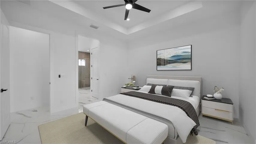 Bedroom featuring a raised ceiling, ensuite bathroom, light marble finish flooring, ceiling fan, and recessed lighting Virtual Staged