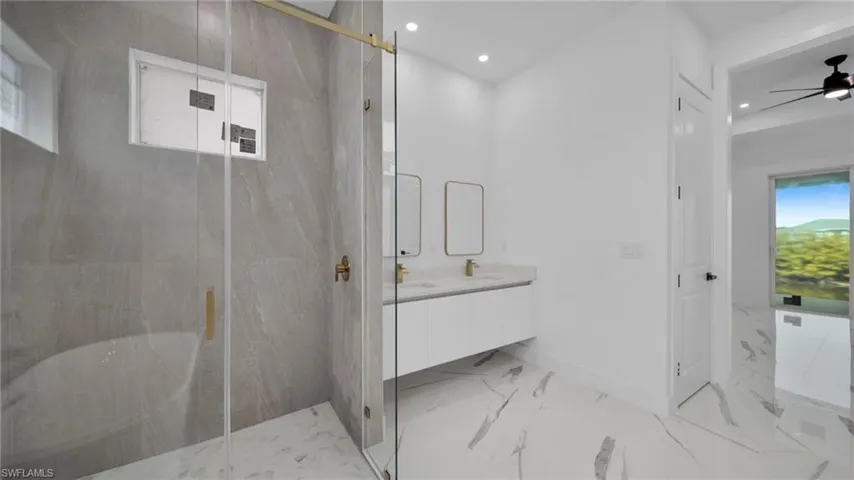 Bathroom featuring a marble finish shower, double vanity, a ceiling fan, and recessed lighting