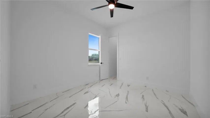 Unfurnished room with ceiling fan and marble finish flooring
