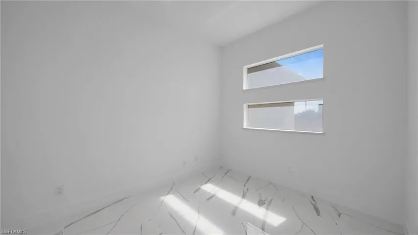 Spare room with baseboards and marble look tiles