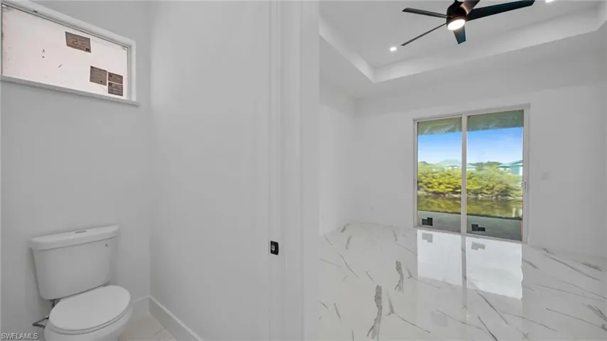 Bathroom featuring a ceiling fan, recessed lighting, and a raised ceiling