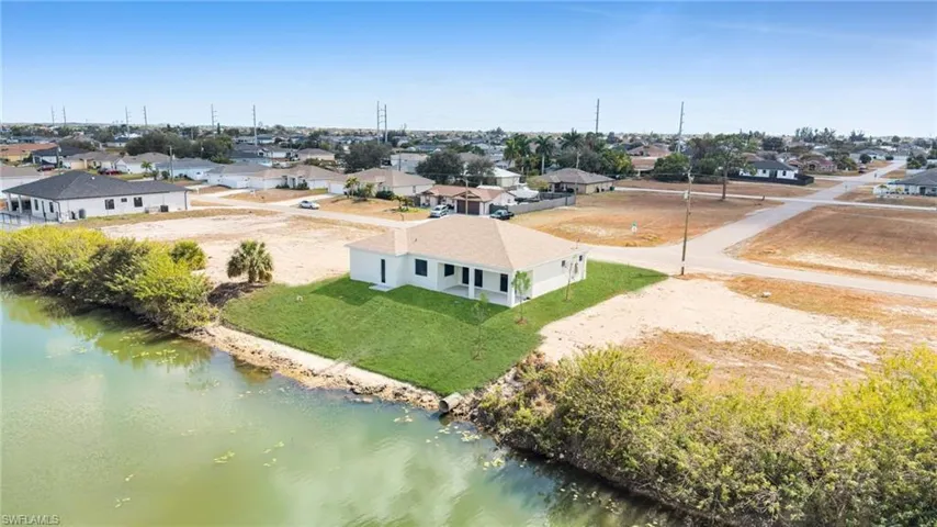 Aerial perspective of suburban area featuring a nearby body of water