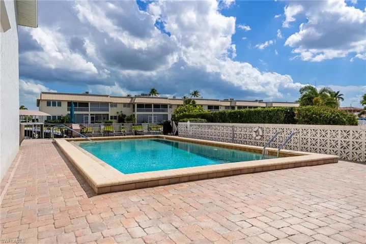 Outdoor swimming pool, paver patio, decorative privacy wall, mature landscaping