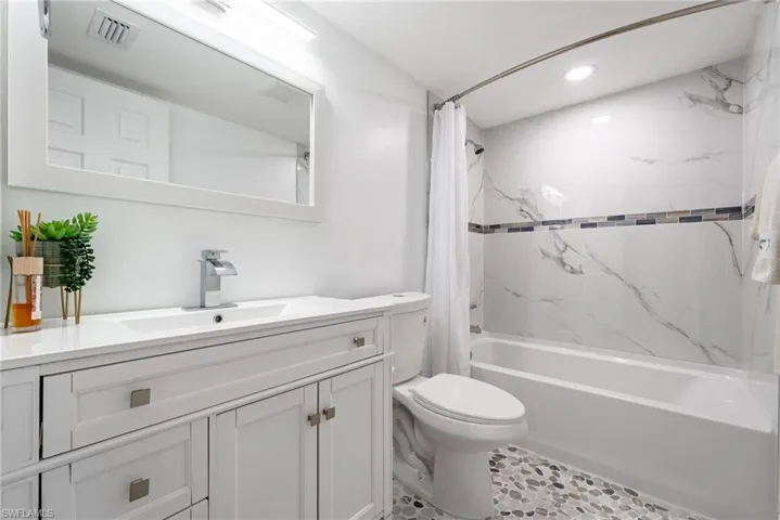Vanity with integrated sink, contemporary chrome faucet, and framed mirror