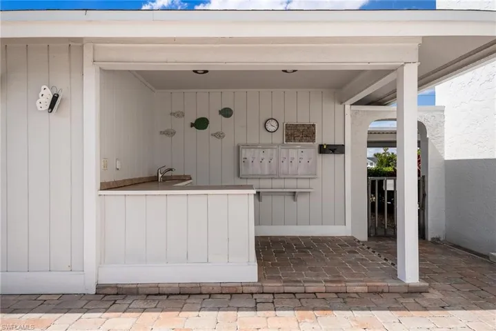 Covered outdoor area featuring a built-in countertop with a sink, recessed lighting, and brick paver flooring