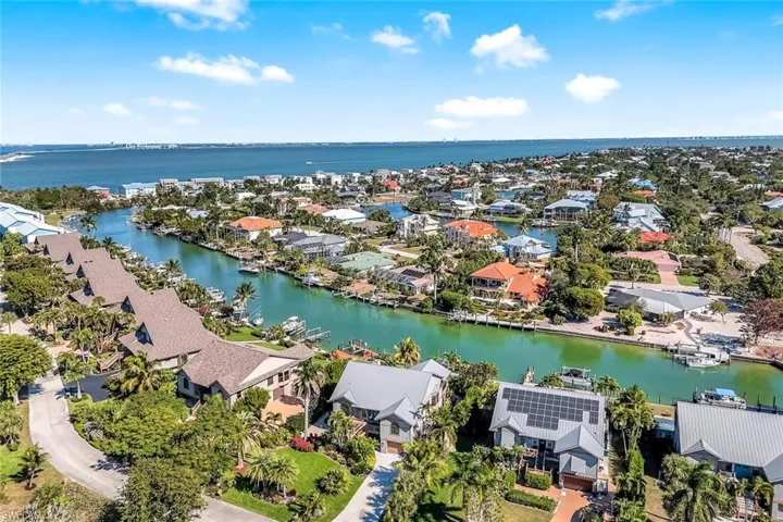 Aerial perspective of suburban area featuring a nearby body of water