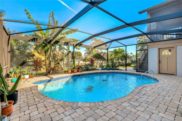 Swimming pool featuring a patio, a lanai, and a sunroom