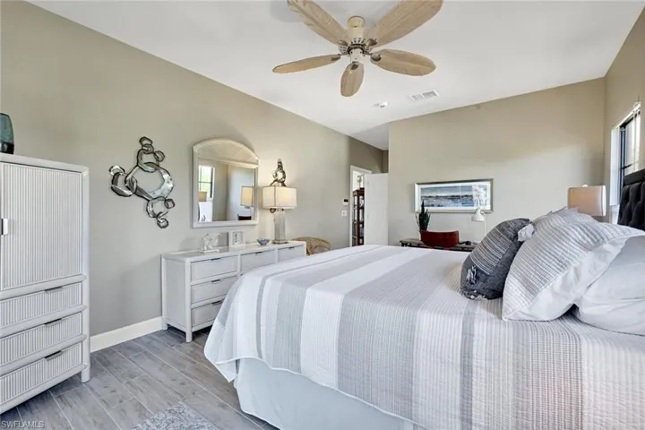 Primary Bedroom featuring wood tiled floors, multiple windows, and ceiling fan