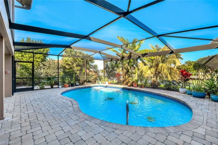Outdoor pool featuring a sunroom, a lanai, and a patio