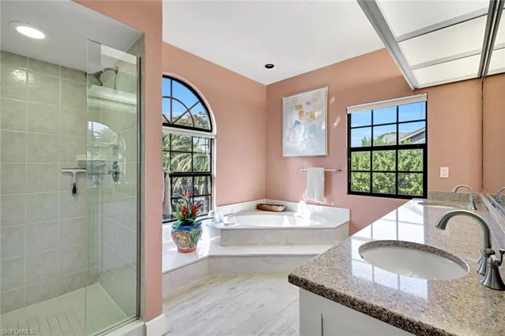 Primary Bathroom with a tile shower, double vanity, and a garden tub