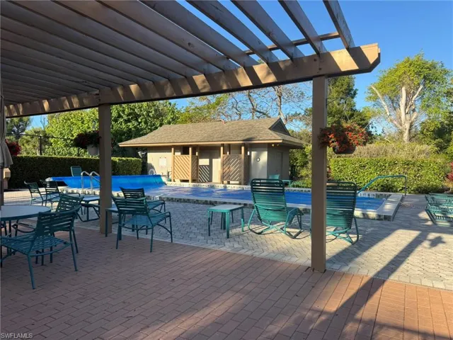 View of pool with a pergola, patio surround, and an outdoor structure