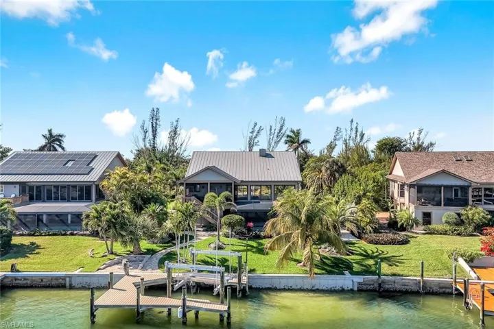 Dock area with boat lift, a sunroom, and a water view