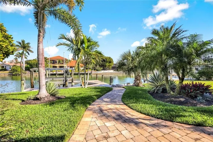 View of property's backyard with boat lift, a dock, and a water view