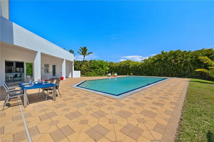 Outdoor pool with a patio and outdoor dining space