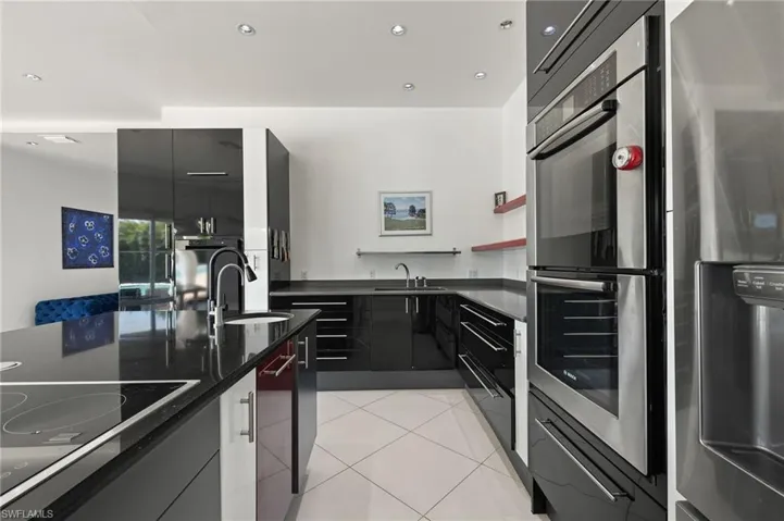Kitchen with light tile patterned floors, appliances with stainless steel finishes, modern cabinets, and a sink