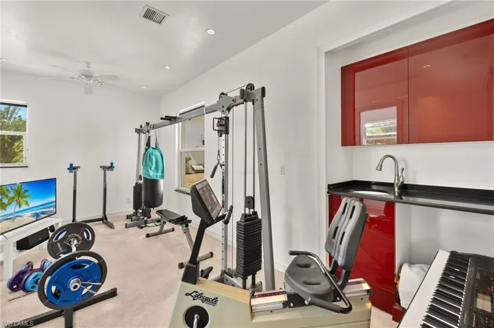 Exercise area with visible vents, a ceiling fan, a sink, recessed lighting, and light colored carpet