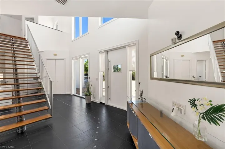 Foyer featuring stairs, visible vents, and a towering ceiling