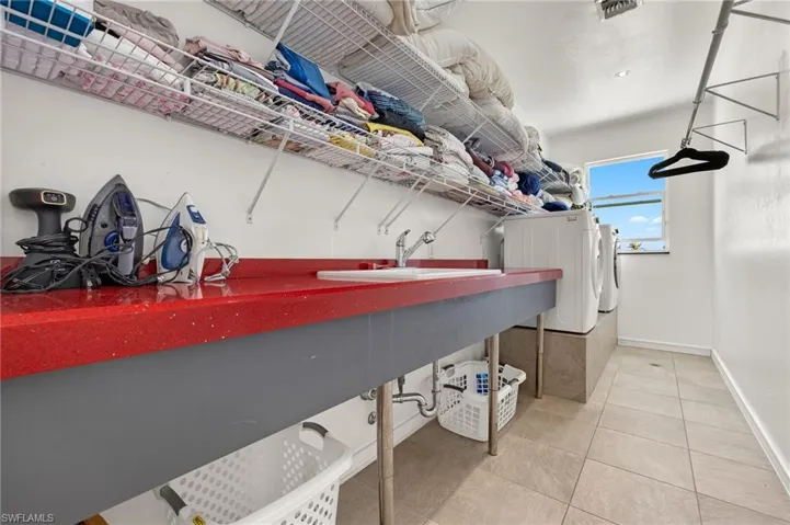 Washroom featuring visible vents, baseboards, washer and clothes dryer, laundry area, and tile patterned floors