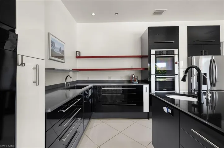 Kitchen with a sink, dark countertops, appliances with stainless steel finishes, and dark cabinets