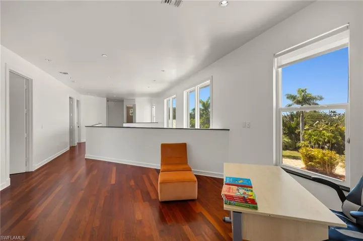 Living area with dark wood finished floors, recessed lighting, and baseboards