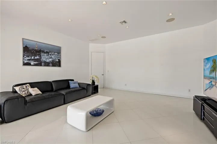 Living room featuring light tile patterned floors, visible vents, recessed lighting, and baseboards