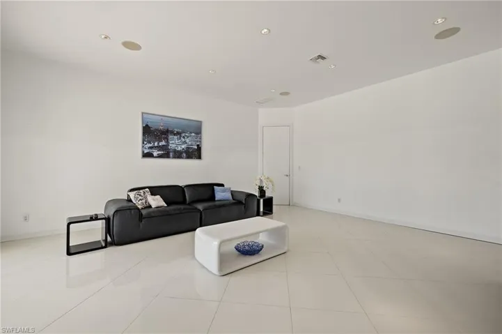 Tiled living area featuring visible vents, recessed lighting, and baseboards