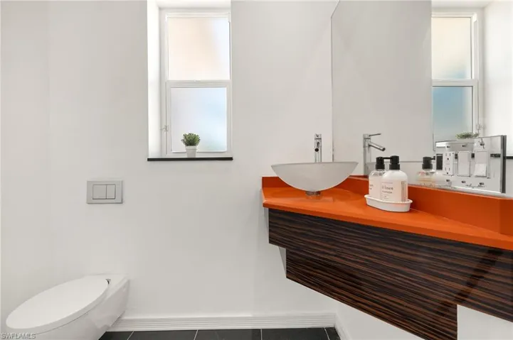 Half bathroom featuring a sink, baseboards, and toilet