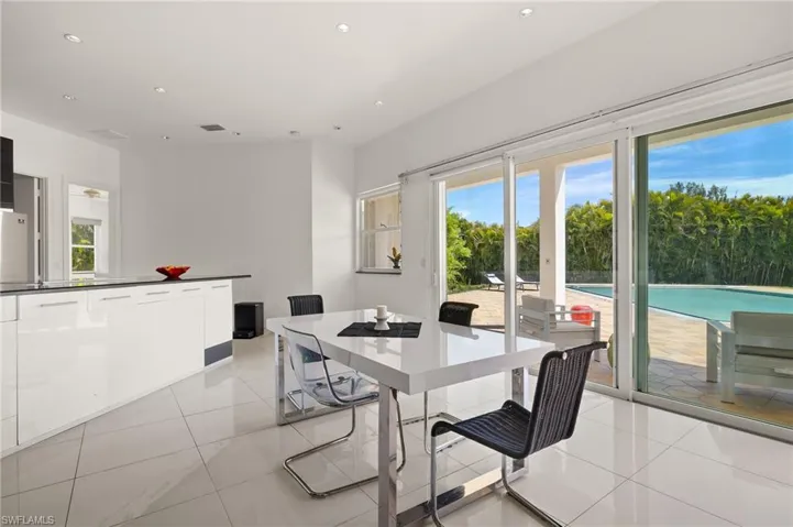 Kitchen featuring modern cabinets, stainless steel appliances, dark countertops, and visible vents