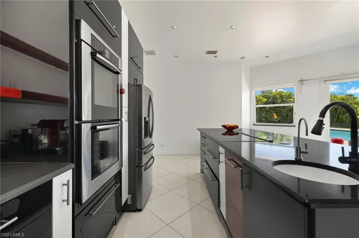 Kitchen with visible vents, modern cabinets, a sink, appliances with stainless steel finishes, and light tile patterned floors