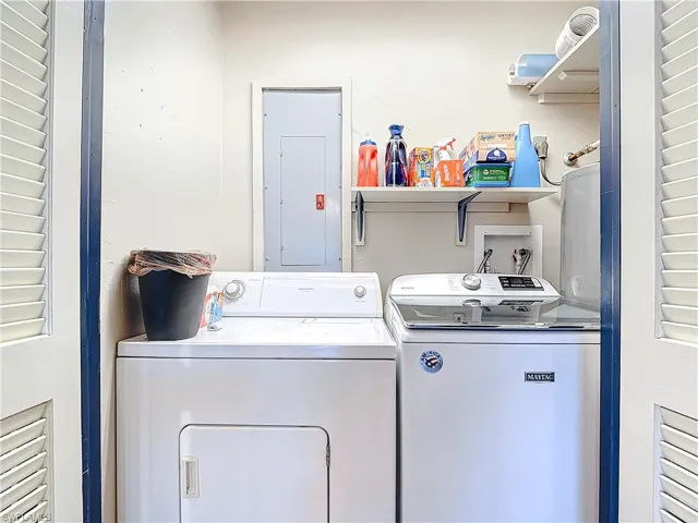 Clothes washing area with laundry area, electric panel, and separate washer and dryer