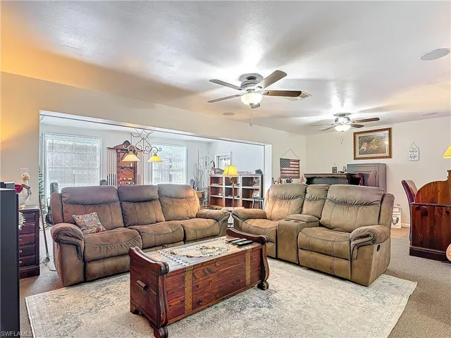 Living area with carpet flooring and ceiling fan