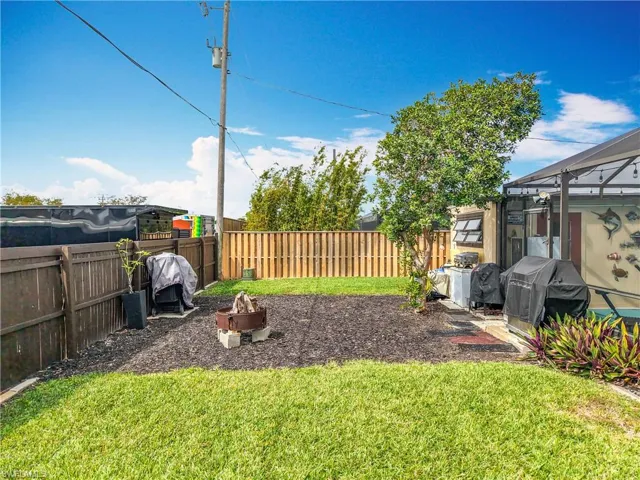 View of yard with an outdoor fire pit and a fenced backyard