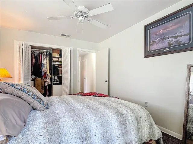 Bedroom with carpet, a closet, visible vents, a ceiling fan, and baseboards