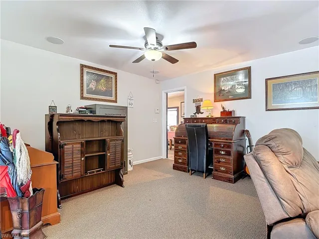 Office featuring carpet flooring, a ceiling fan, and baseboards