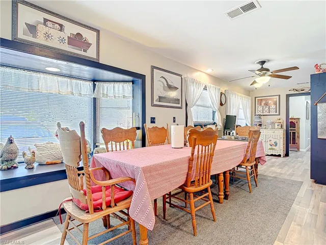 Dining room with a ceiling fan, visible vents, light wood-style flooring, and baseboards