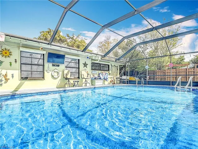 View of swimming pool featuring a lanai, fence, a fenced in pool, and a patio
