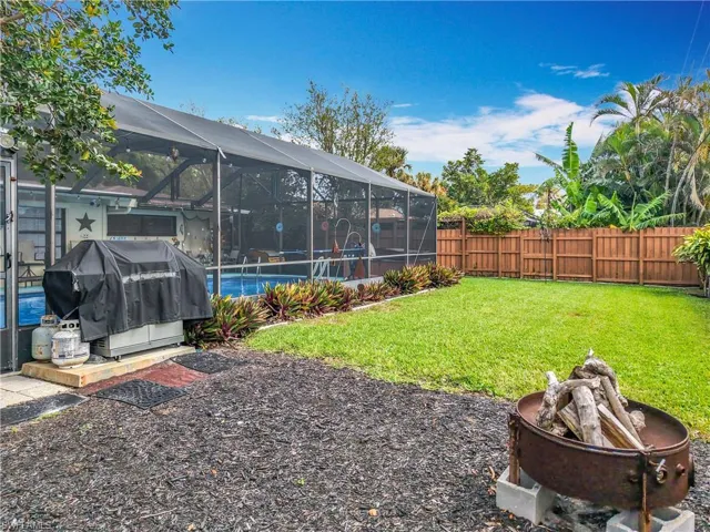 View of yard featuring a swimming pool, a fenced backyard, and a lanai