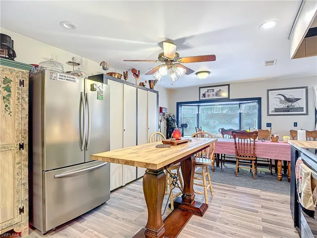 Kitchen featuring visible vents, light wood-style flooring, freestanding refrigerator, and a ceiling fan