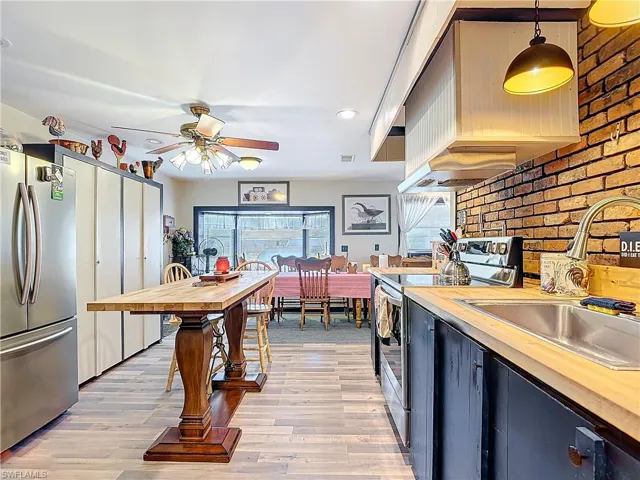 Kitchen featuring stainless steel appliances, light wood-type flooring, a sink, and wood counters