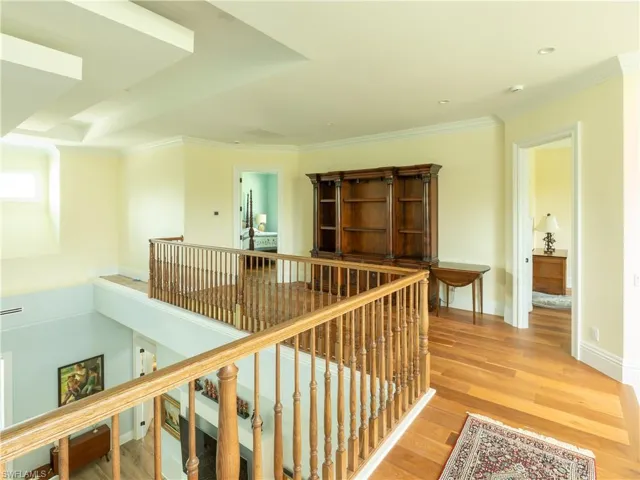 Hallway with an upstairs landing, light wood-type flooring, crown molding, recessed lighting, and baseboards