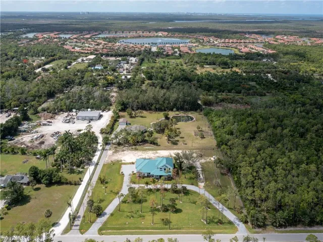 Aerial overview of property's location with a nearby body of water and a forest