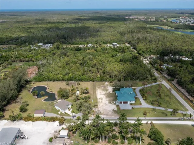 Aerial overview of property's location with a heavily wooded area and a nearby body of water