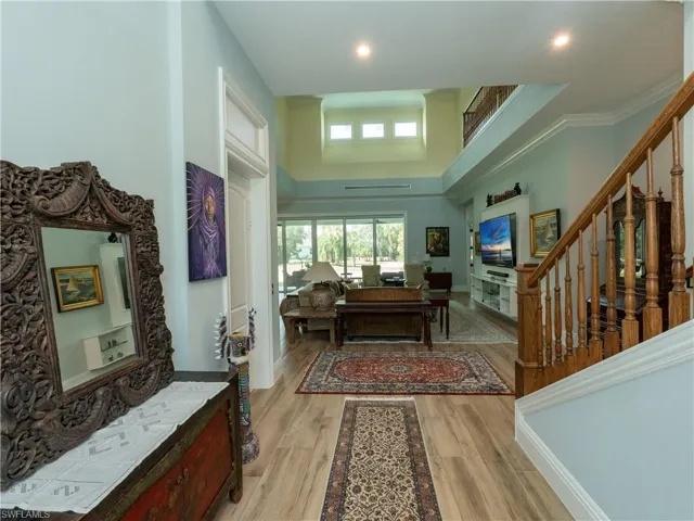 Entryway with a towering ceiling, stairs, light wood-type flooring, and recessed lighting
