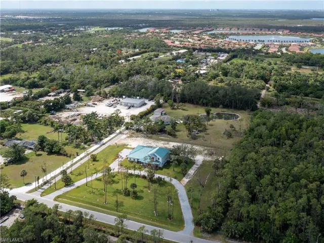 Aerial view of property's location with a large body of water and a forest